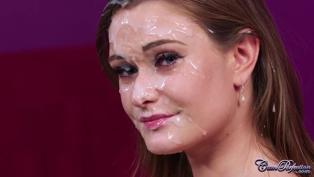 Honorez May à genoux, le visage entièrement recouvert de sperme